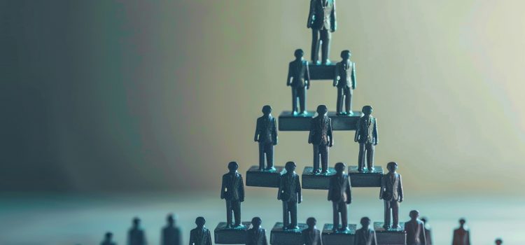 Mini figurines in business suits standing in a pyramid, representing a workplace hierarchy.