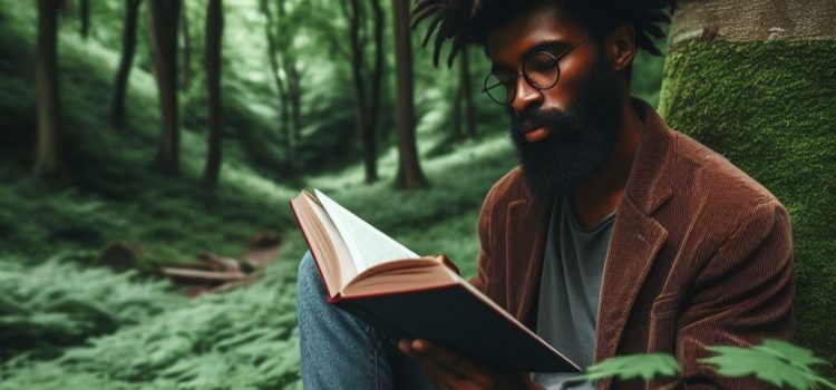 a man sitting in the forest, leaning against a tree, and reading a book