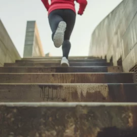 A person running up steep stairs, showing how to stay committed to your goals