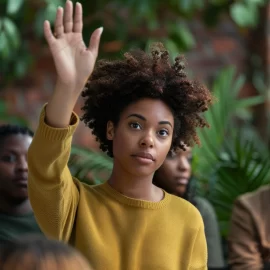 A woman raising her hand in a crowd, learning how to accept responsibility for her actions.