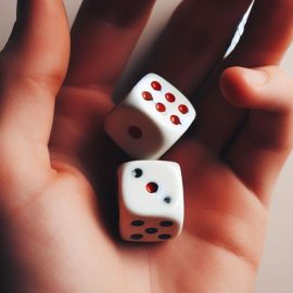 A person holding a pair of dice in their hand illustrates quantum indeterminacy and free will