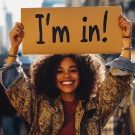 a smiling woman on a city street holding a sign that says "I'm in!" illustrates that people are susceptible to influence