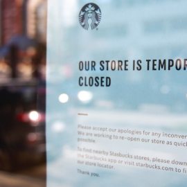 A closed sign on the window of a Starbucks store that shows a Starbucks crisis