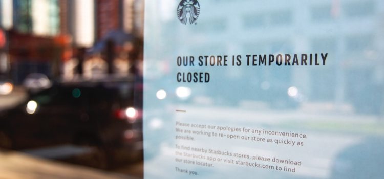 A closed sign on the window of a Starbucks store that shows a Starbucks crisis