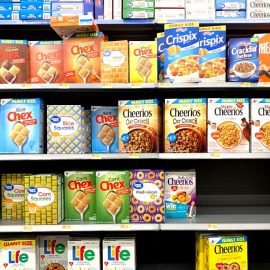 Boxes of cereal on a shelf in a grocery store signifying the lack of processed food regulations