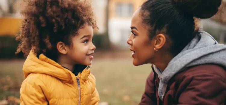 A mother talking to her daughter at eye-level, using respectful parenting communication skills