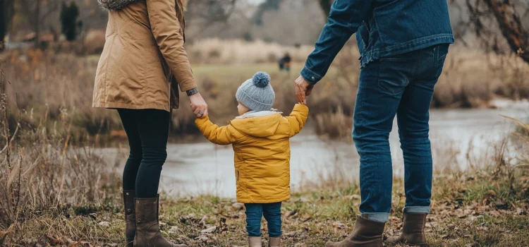 Parents holding their child outside in the fal, knowing how to raise good kids