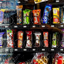 A vending machine full of addictive, ultra-processed junk food, such as chips and chocolate bars