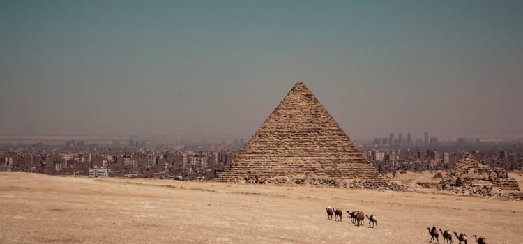 An ancient pyramid in Egypt with modern cities in the distance illustrates the rise and fall of empires