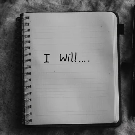 A notebook that says "I will..." representing how to write affirmations for yourself