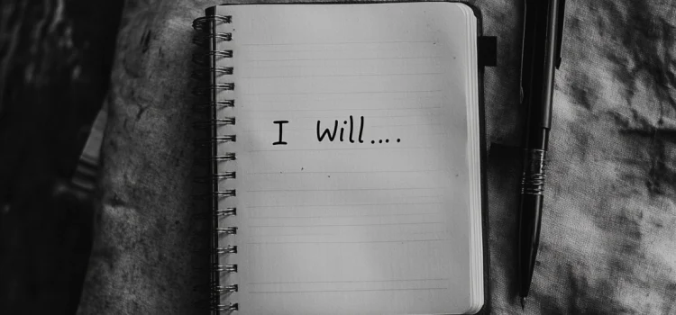 A notebook that says "I will..." representing how to write affirmations for yourself