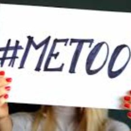 A woman holding up a sign that reads "#MeToo," showing the impact of me too movement