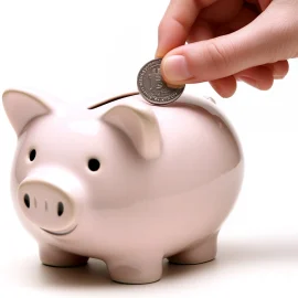 A person making a good financial habit by adding a coin to a piggy bank