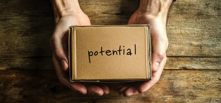 A person holding a cardboard box to tap into their potential, with the word "potential" written on it