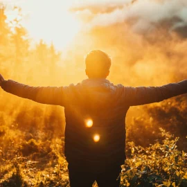 A man who knows how to replenish his energy, holding his arms out in front of the sun