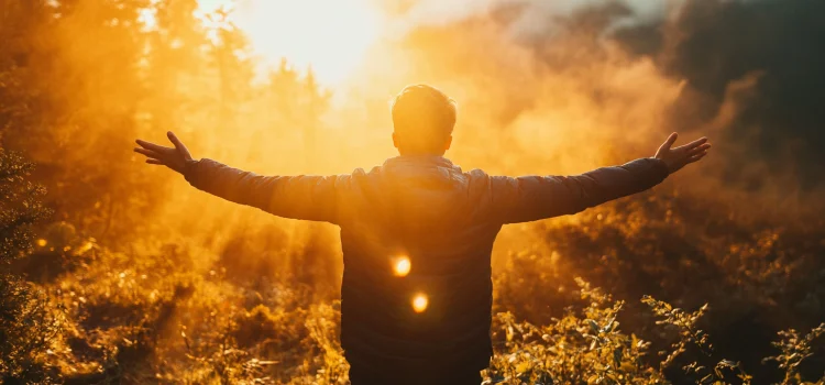 A man who knows how to replenish his energy, holding his arms out in front of the sun