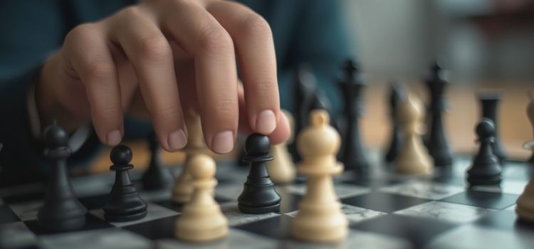 A person's hand picking up a pawn on a chess board illustrates the tricky situation of the Ottoman Empire before WWI