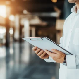 A salesperson holding a clipboard in a building