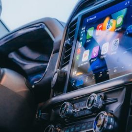 A center console in a car that includes physical buttons and a screen