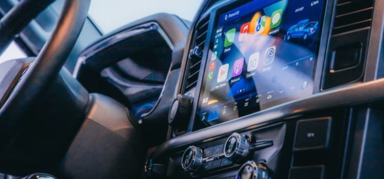 A center console in a car that includes physical buttons and a screen