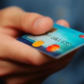 A person holding a credit card, showing what the credit cycle is