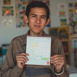 A man holding a written schedule illustrates positive self-pressure