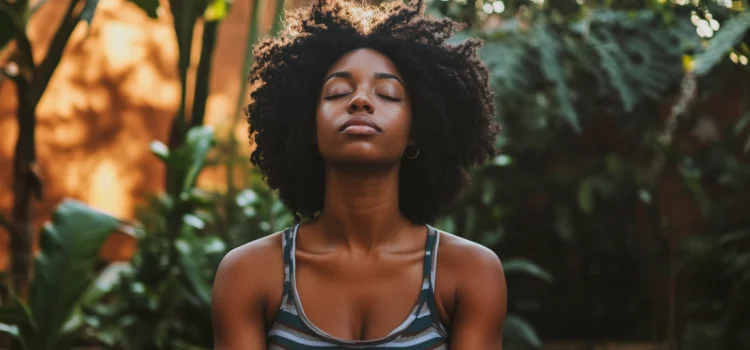 A woman practicing self-care outside by meditating