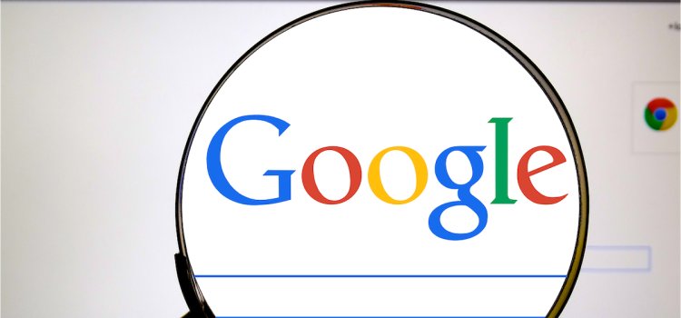 A magnifying glass magnifying "Google" on the Google search homepage illustrates the Google antitrust ruling