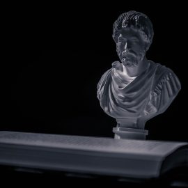 A bust of Seneca and an open book illustrate Seneca's writing