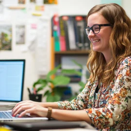 A female employee happily working at her desk, showing her flexibility and adaptability in the workplace