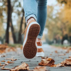 A person running on a sidewalk in nature, learning how to build momentum