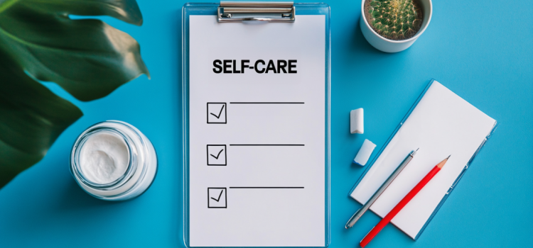 A daily self-care checklist next to pens and a drink on a blue background