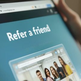 A person holding a tablet and looking at a webpage that says "Refer a friend" illustrates how to reach new customers
